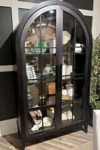 a rounded, arched black glass door cabinet