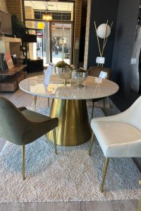 round marble top dining table with gold base and 2 dining chairs with gold legs