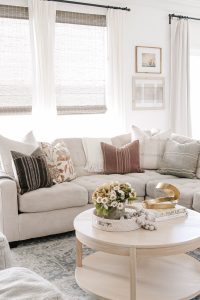 Living Room Sofa Styling of A light and airy cream sofa with lots of throw pillows varying in size, pattern, and texture.